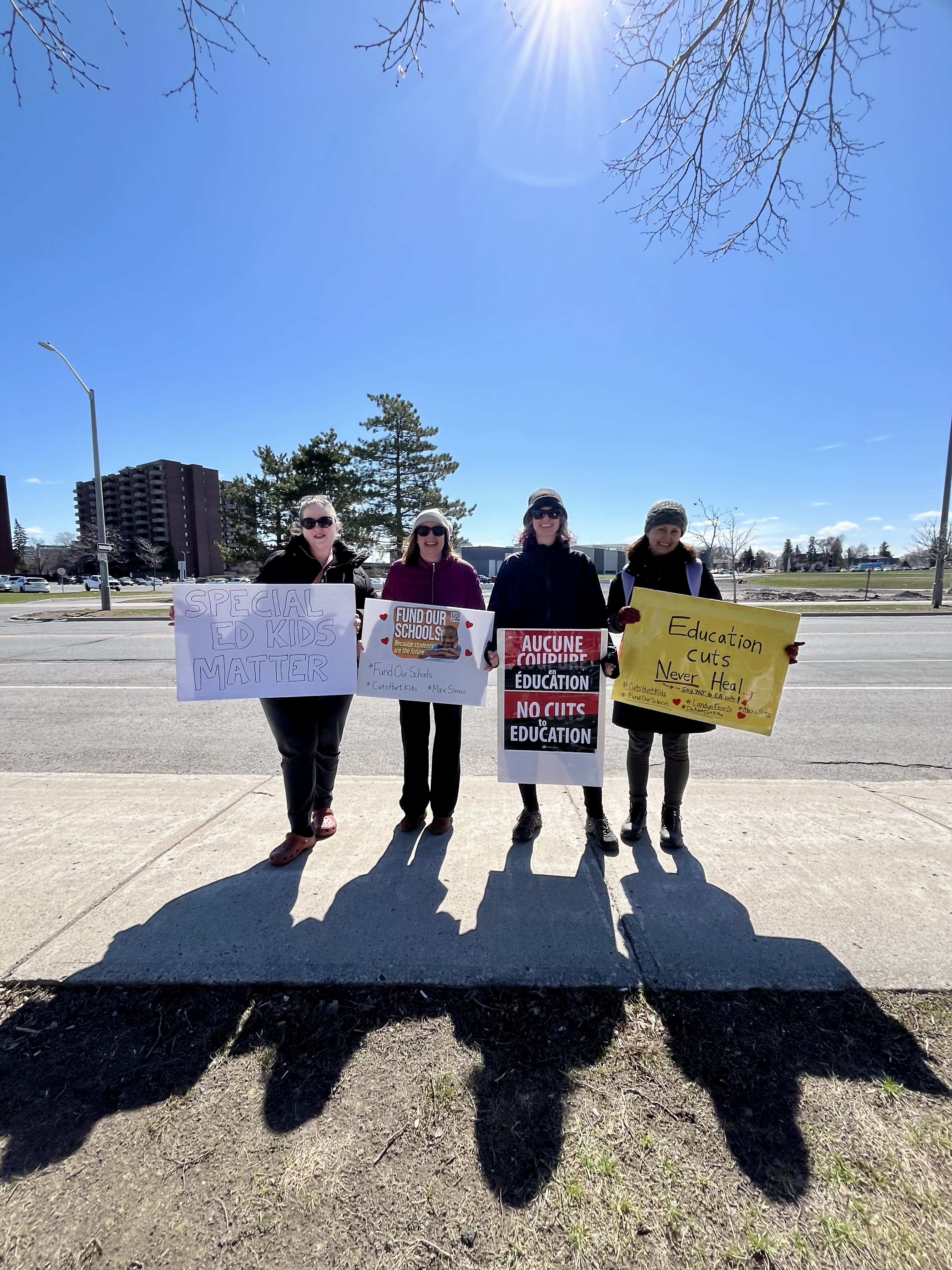 Four education advocates holding signs supporting special education students